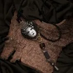 Neck jewellery with face-shaped pendant
