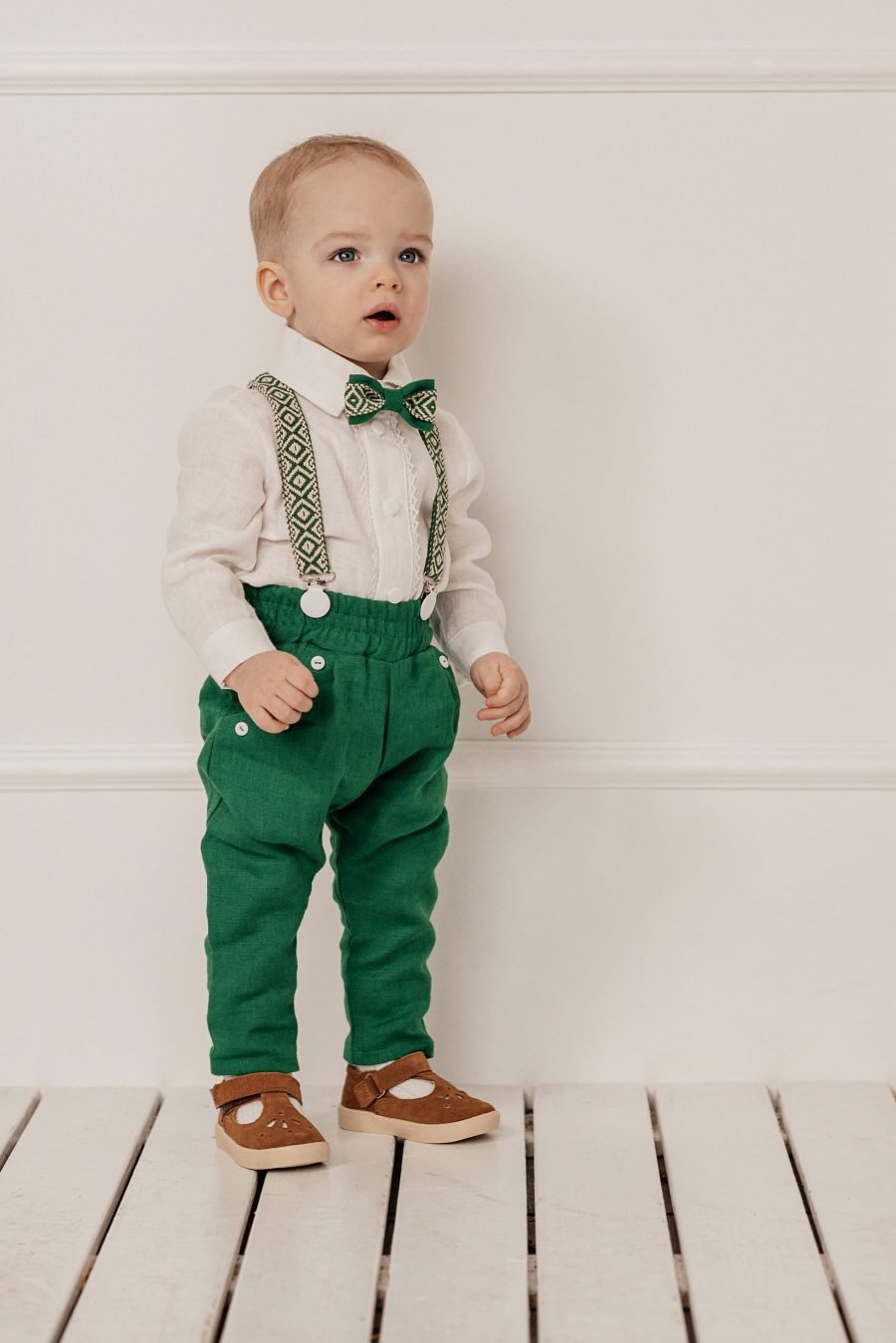 Green linen suit with patterned shoulder straps, bowtie